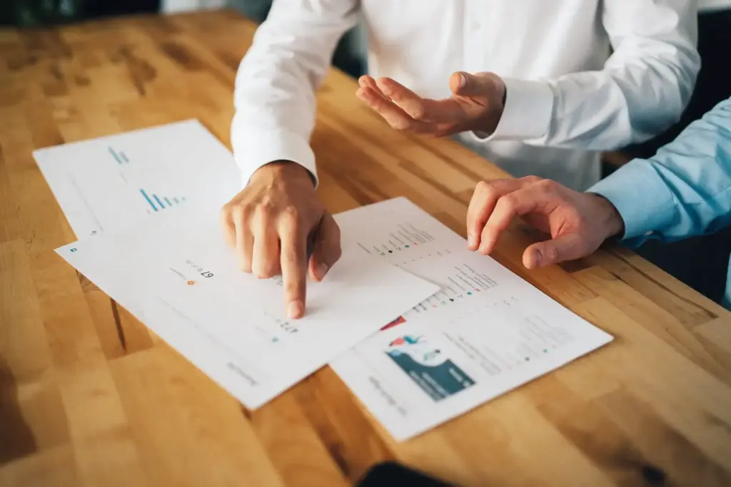 Detaillierte Datenanalyse im Marketing bei Blobel Consulting, zwei Berater überprüfen und diskutieren Strategie-Dokumente und Statistiken.